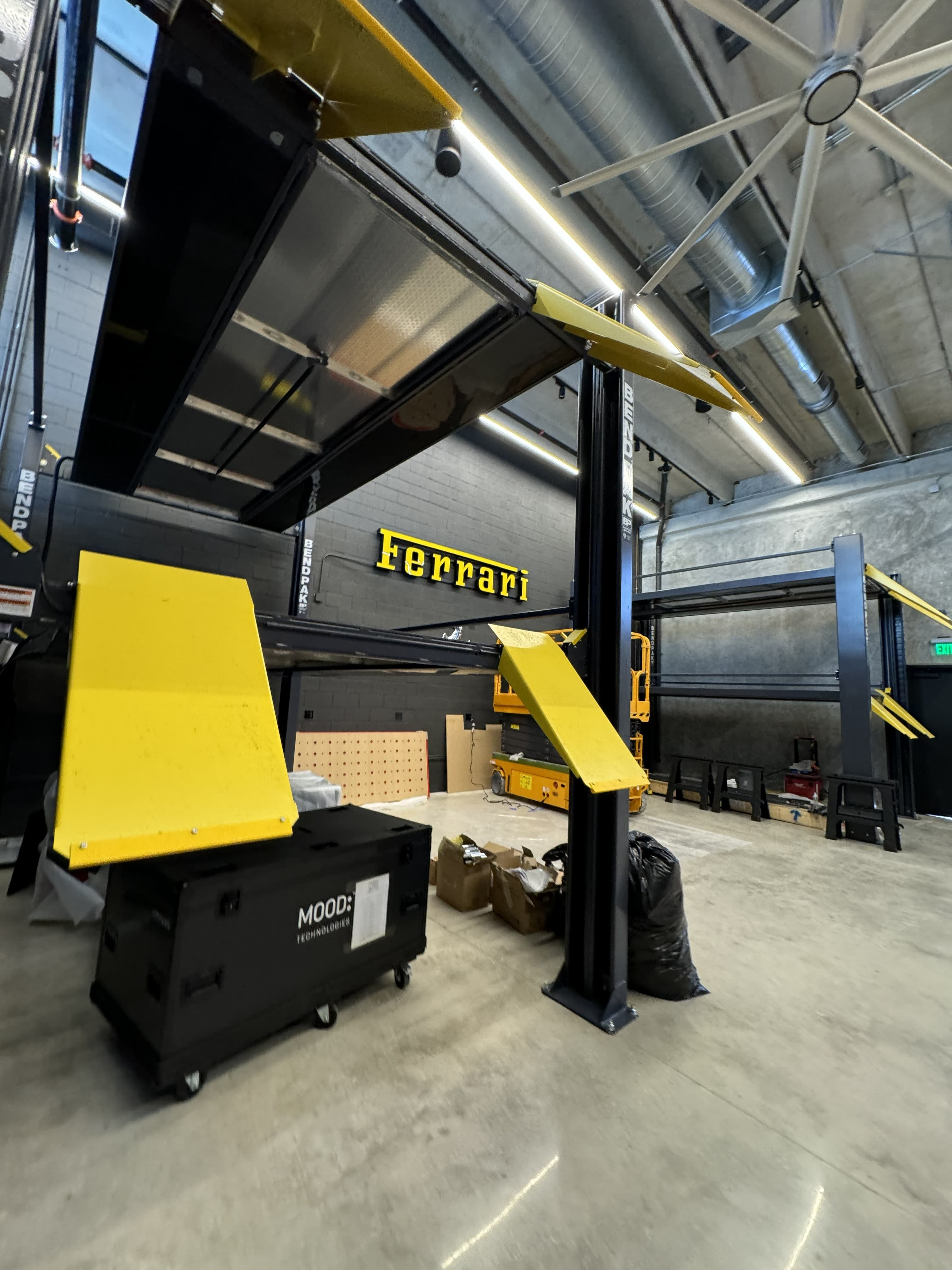 Vehicle lift structure and overhead lighting installation in a commercial service facility